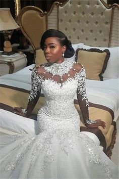 a woman in a wedding dress sitting on a bed