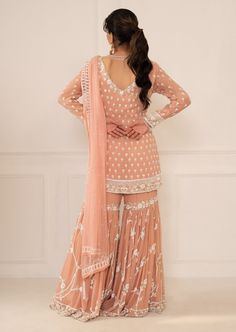 Editor's Note Featuring Peach Pink Embroidered Shirt & Gharara Set With Dupatta Fabric: Silk, Chiffon Color: Peach Pink Embroidery Details: Zardozi Hand Embroidery Care: Dry Clean Only About the Designer Mani Bhatia's collection which is a union of sophistication and comfort infused with aesthetics and calming shades.Mani Bhatia make sure to permeate life in our traditional designs with modern looks through opposing colours White Tan Outfit, Bridal Sarees Online, Punjabi Suits Party Wear, Tan Outfit, Sharara Suits, Desi Wear, Pink Embroidery, Anarkali Gown, Sharara Set