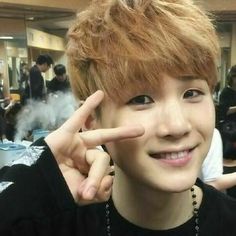 a young man making the peace sign with his fingers