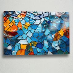 a colorful piece of art hanging on the side of a wall with glass shards all over it