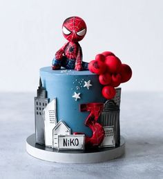 a spiderman cake with red balloons on top