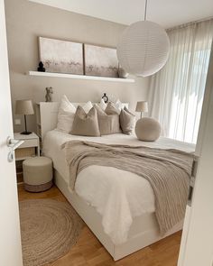 a white bed sitting in a bedroom next to two lamps