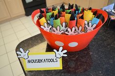 a bowl filled with lots of markers on top of a counter