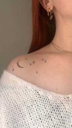 a woman's back shoulder with stars and moon tattoos on her left upper arm