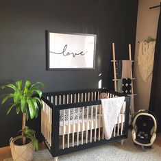 a black and white baby's room with a love sign above the crib