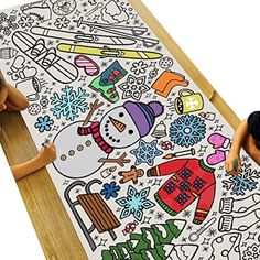 two dolls sitting on the floor next to a large coloring book