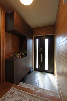 a room with a door and some shelves on the wall next to an area rug