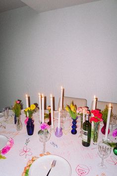 the table is set with flowers and candles