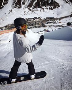 a snowboarder is posing for a photo on the top of a snowy mountain