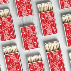 matches are lined up on a table with red and white matchboxes next to each other