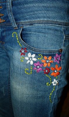 a pair of jeans with embroidered flowers on them