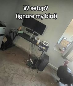 a man sitting in front of a tv next to a desk with a monitor on it