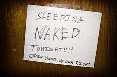 a piece of paper with the words sleeping naked written on it is attached to a door