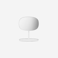 a white table with a round mirror on it's top and an oval base