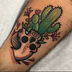 a man's arm with a skull and cacti tattoo design on it