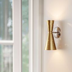 a wall light that is on the side of a door with a window in the background