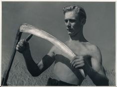 an old photo of a shirtless man holding a large object in his right hand