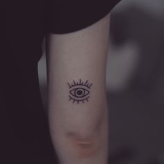 a woman's arm with an eye tattoo on it