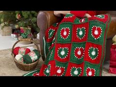 a woman sitting in a chair with a crocheted christmas blanket on her lap