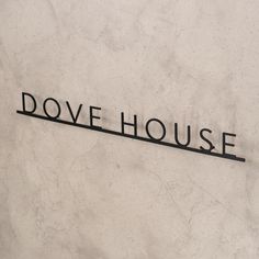 a sign that reads dove house on the side of a building in front of a clock