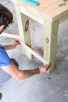 a man is working on a table made out of wood