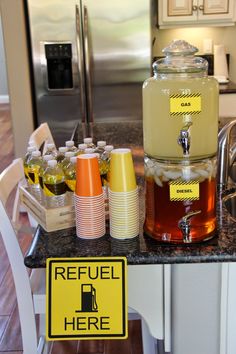 a kitchen counter topped with lots of bottles and containers filled with liquid next to a refrigerator