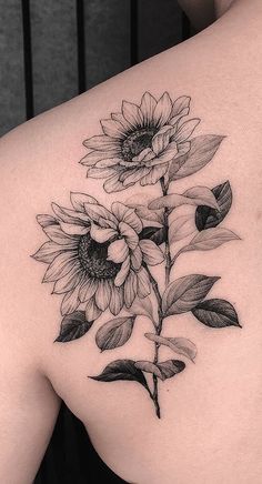 a sunflower tattoo on the back of a woman's upper arm and shoulder