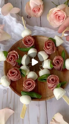 a wooden plate topped with roses and marshmallows