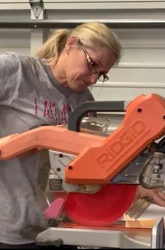 a woman using a circular saw to cut wood