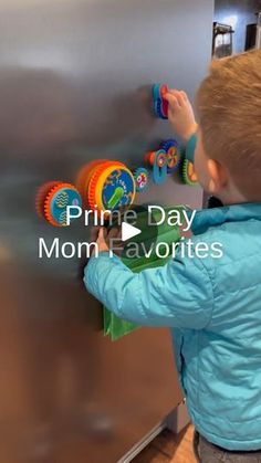 a little boy playing with magnets on the refrigerator