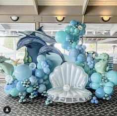 an ocean themed balloon display with dolphins, dolphins and seashells on the floor