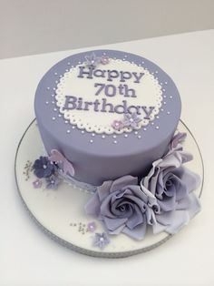 a birthday cake with purple frosting and flowers