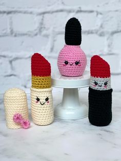 four crocheted items sitting on top of a white cake plate next to each other