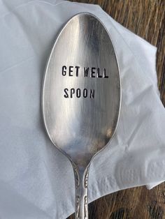 a spoon with the words get well spoon on it sitting on top of a napkin