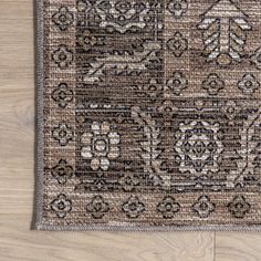 a brown and black rug on top of a wooden floor