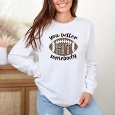 A cute Football shirt with a funny saying, and an added cheetah print flair! Super cute for anyone on the bleachers cheering for their favorite football team!  This is a unisex style shirt, so ladies if you want a more "true to size" fit I would size down one. Short sleeve and sweatshirt version available here!: https://www.etsy.com/listing/1000732017/football-shirt-for-moms-leopard-football?click_key=aff50ca53528c013be26a368a53a497f8fd877e3%3A1000732017&click_sum=531a27f0&ref=shop_home_active_1 Football Sayings For Shirts, White Long Sleeve Tops With Funny Text, White Tops With Funny Text For School Spirit, Cotton Top With Funny Text For Game Day, Long Sleeve Graphic Tee With Funny Text, School Spirit Crew Neck Tops With Funny Print, Funny Print Crew Neck Tops For School Spirit, Casual T-shirt With Funny Text For Game Day, Funny Print Crew Neck Top For Game Day