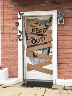 a door that has been decorated with cardboard taped to it and the words keep out