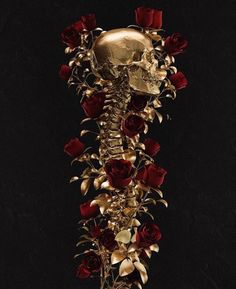 a gold skull with red roses on it