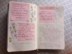 an open notebook with notes written on it and flowers in the pages next to each other