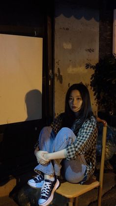 a woman sitting on top of a wooden chair