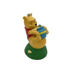 a winnie the pooh figurine sitting on top of a ball