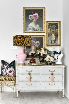 a white dresser topped with lots of pictures and flowers