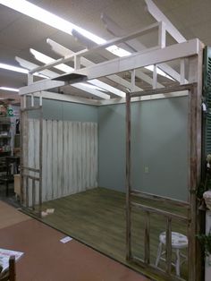 an empty room with wooden flooring and white boards on the ceiling, surrounded by green shutters