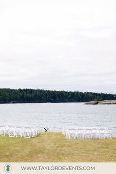 rows of white chairs are set up in front of the water for an outdoor ceremony