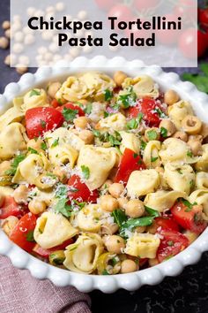 chicken tortellini pasta salad in a white bowl with tomatoes, chickpea and parmesan cheese