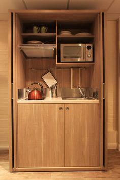 a microwave oven sitting on top of a wooden cabinet