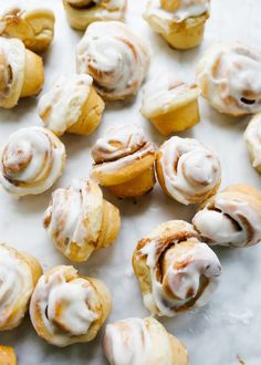 cinnamon rolls with icing sitting on top of a table