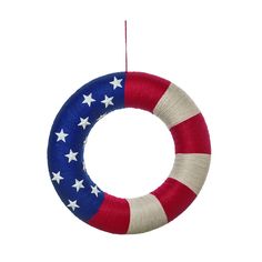 a red, white and blue wreath ornament hanging from a thread spool