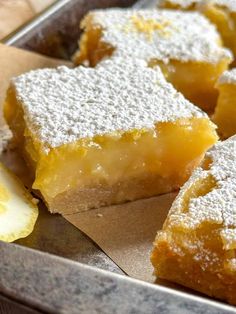 lemon bars with powdered sugar on top in a pan