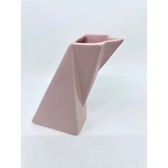 a pink vase sitting on top of a white table